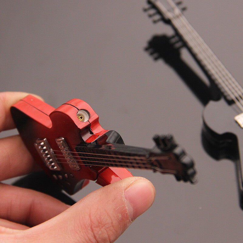 Guitar-shaped torch lighter with black strings held by a gloved hand
