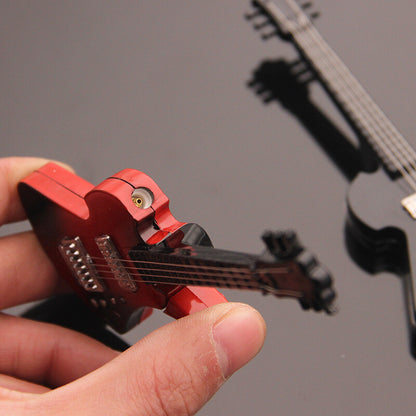 Guitar-shaped torch lighter with black strings held by a gloved hand